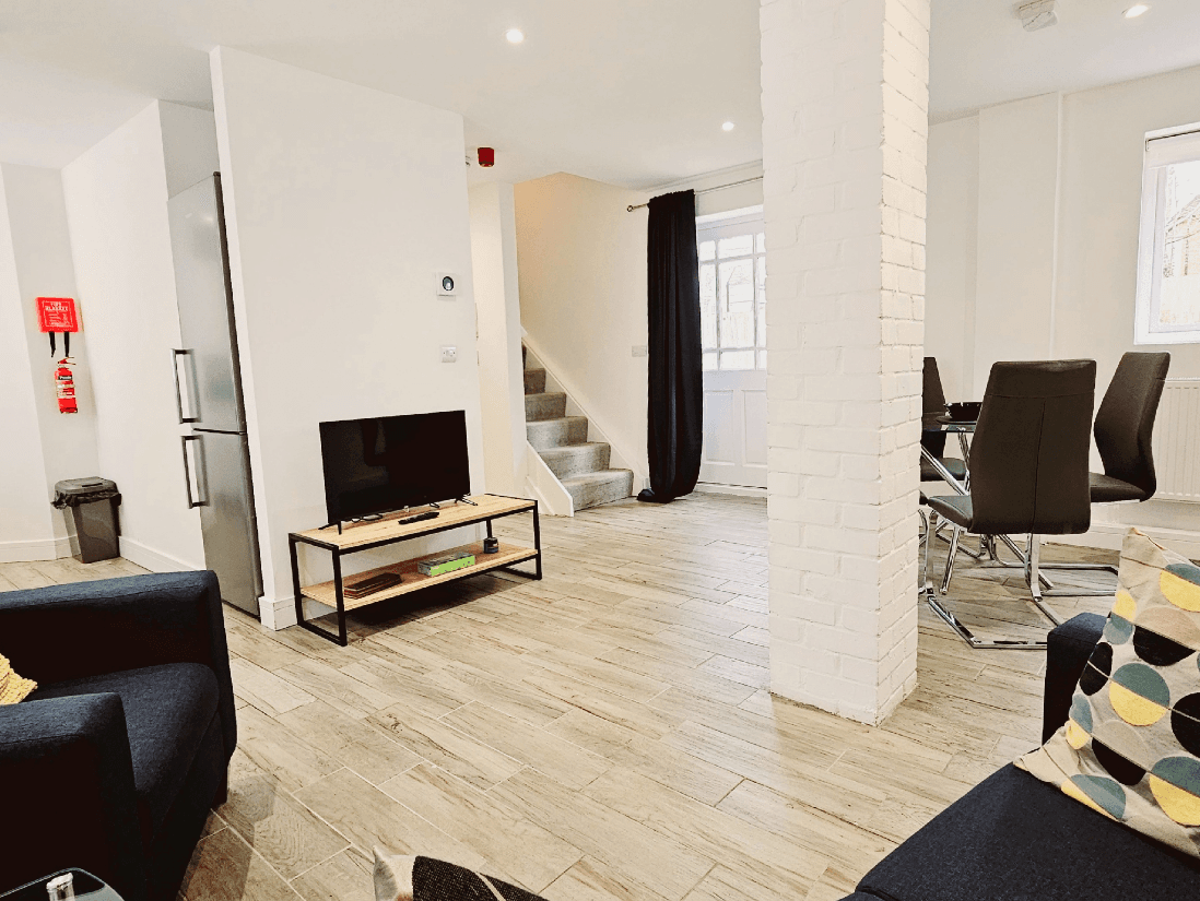 Spacious living room with modern sofas and flat-screen TV in The Maple Suite, Farnham Spacious living room with modern sofas and flat-screen TV in The Maple Suite, Farnham