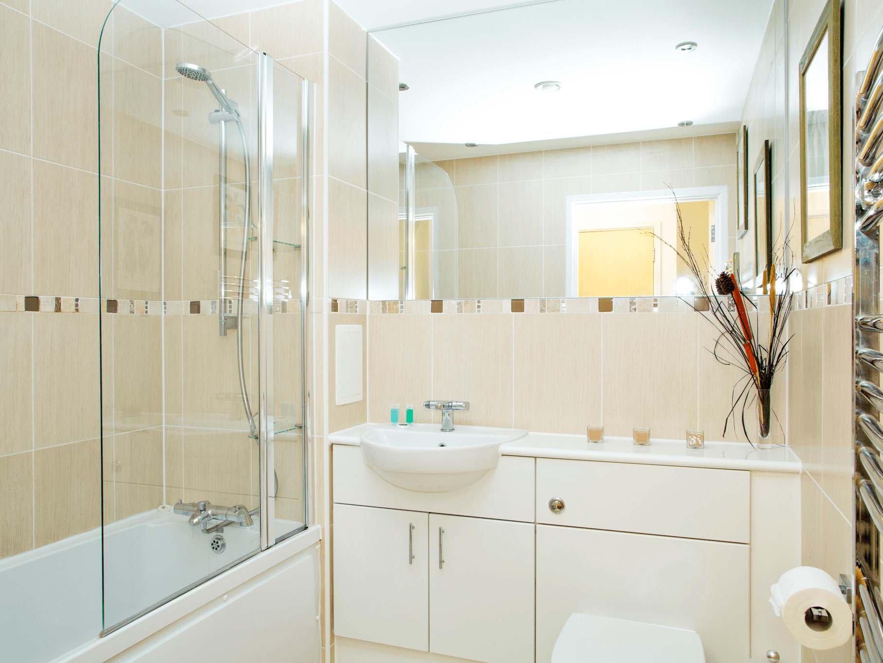 Modern family bathroom with bathtub, overhead shower, and large wall mirror at The Willow Suite, Cardinal Place, Woking Modern family bathroom with bathtub, overhead shower, and large wall mirror at The Willow Suite, Cardinal Place, Woking