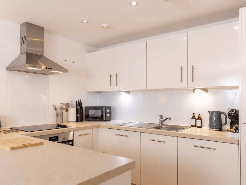 Contemporary open-plan kitchen with integrated oven and white cabinetry at The Sycamore Suite, Enterprise Place, Woking Contemporary open-plan kitchen with integrated oven and white cabinetry at The Sycamore Suite, Enterprise Place, Woking