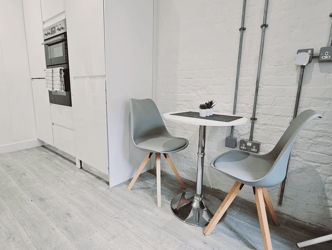 Fully fitted kitchen with oven, minimalist décor, and café-style dining table in The Oak Suite, Farnham Fully fitted kitchen with oven, minimalist décor, and café-style dining table in The Oak Suite, Farnham