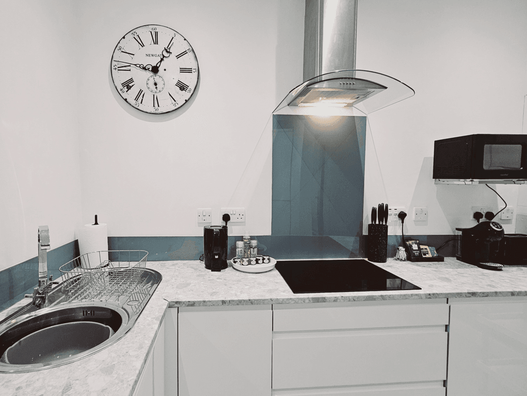 Contemporary kitchen with hob, extractor fan, and integrated appliances at The Oak Suite, Farnham Contemporary kitchen with hob, extractor fan, and integrated appliances at The Oak Suite, Farnham