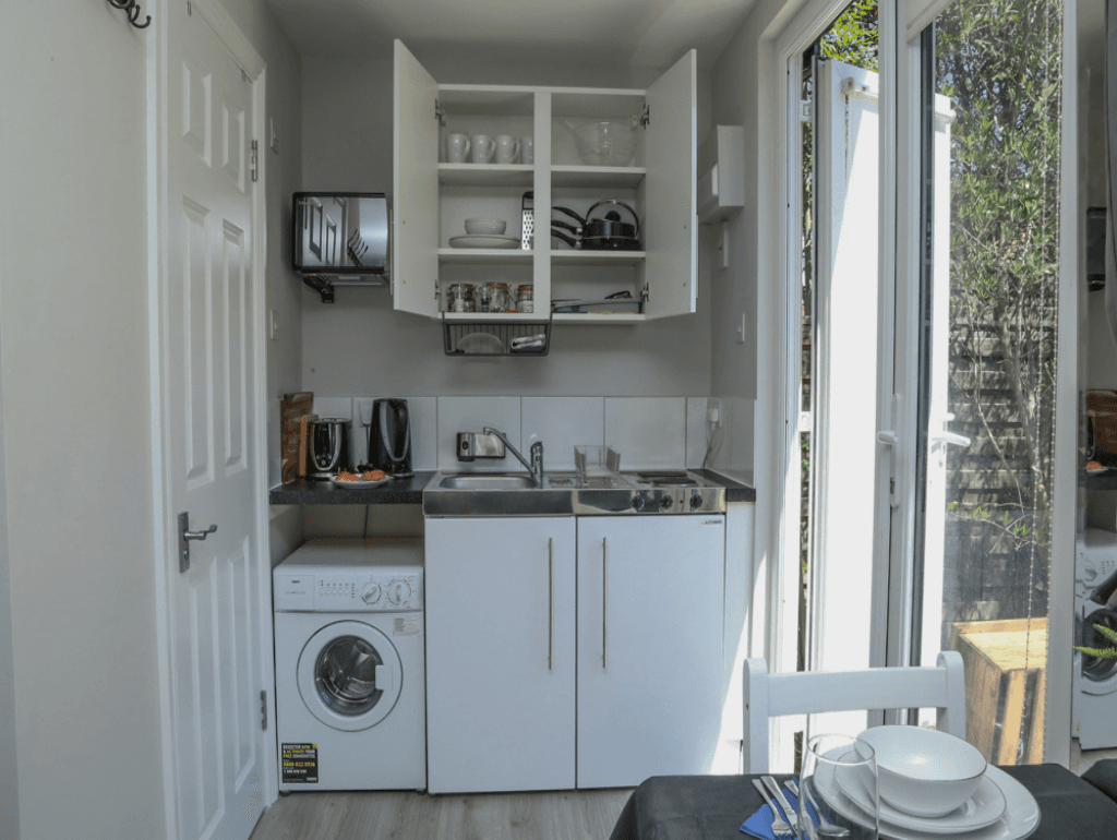 Modern kitchenette with integrated appliances, cabinets, and washing machine – Crofton Park, London Modern kitchenette with integrated appliances, cabinets, and washing machine – Crofton Park, London