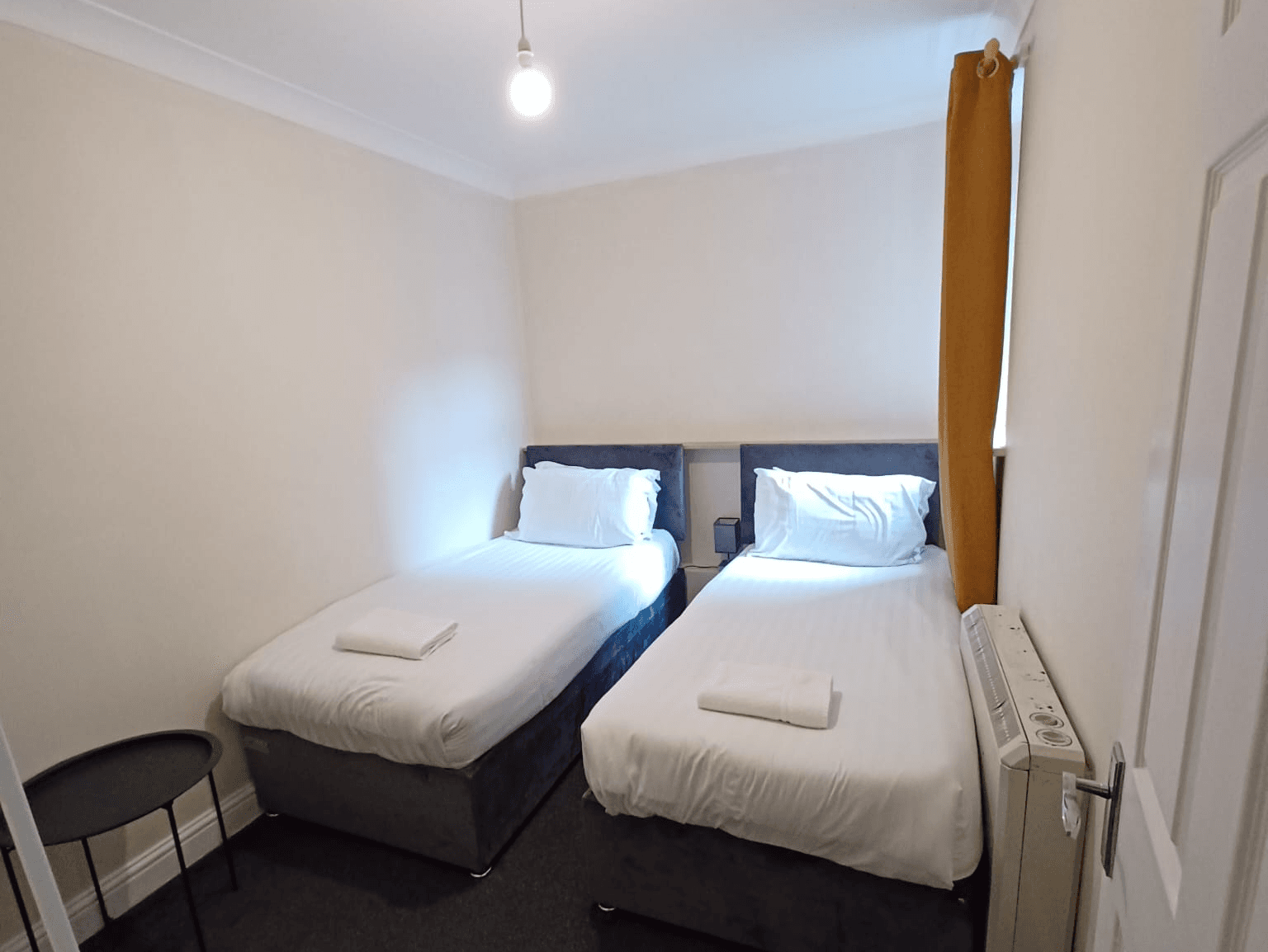 Twin bedroom with two single beds, white linen, and large window – Wilton H1 - Southampton Twin bedroom with two single beds, white linen, and large window – Wilton H1 - Southampton