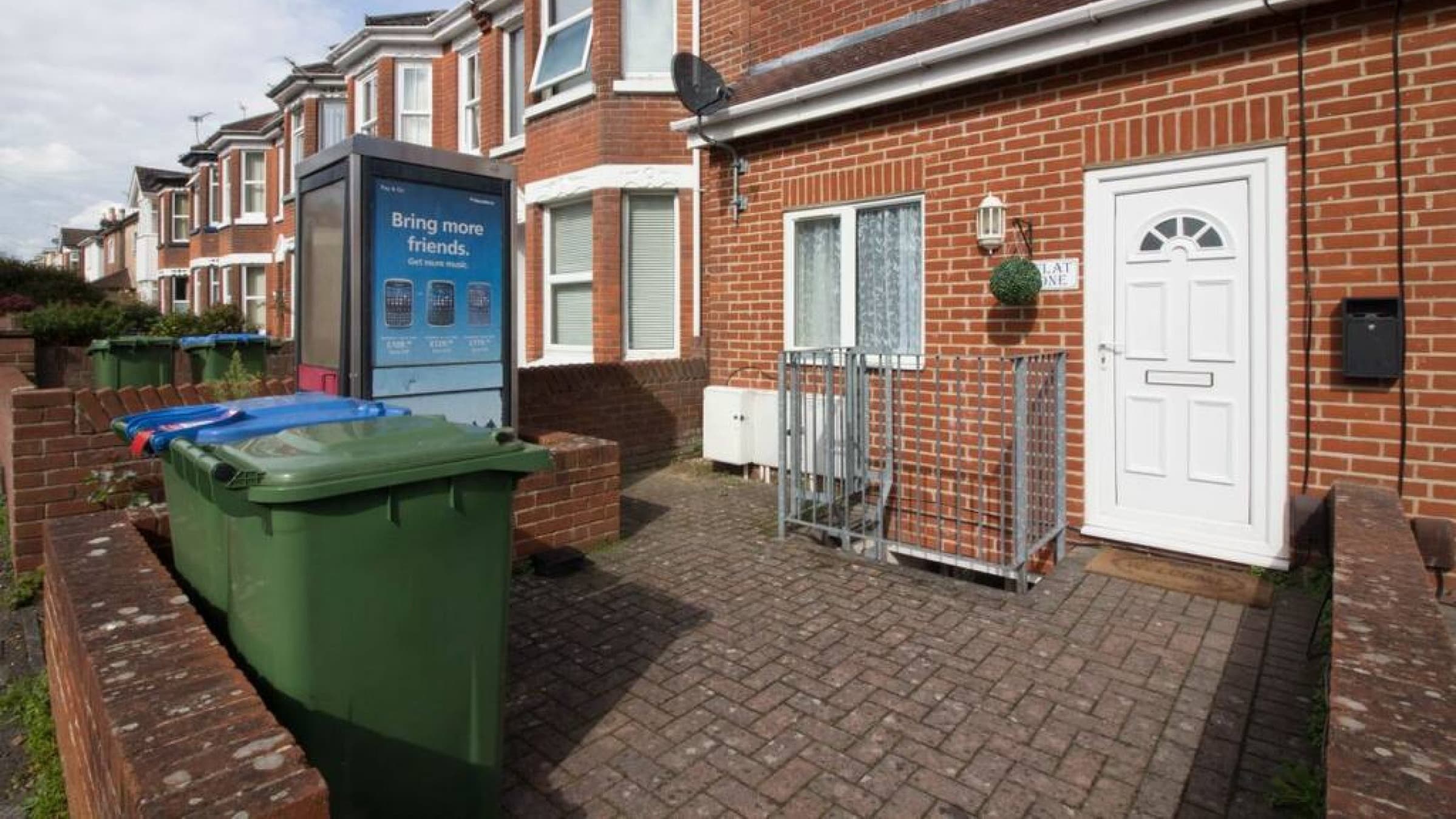 Exterior view of red brick Wilton H1 house with white trim, tidy front garden, and bin storage – Wilton H1 - Southampton Exterior view of red brick Wilton H1 house with white trim, tidy front garden, and bin storage – Wilton H1 - Southampton