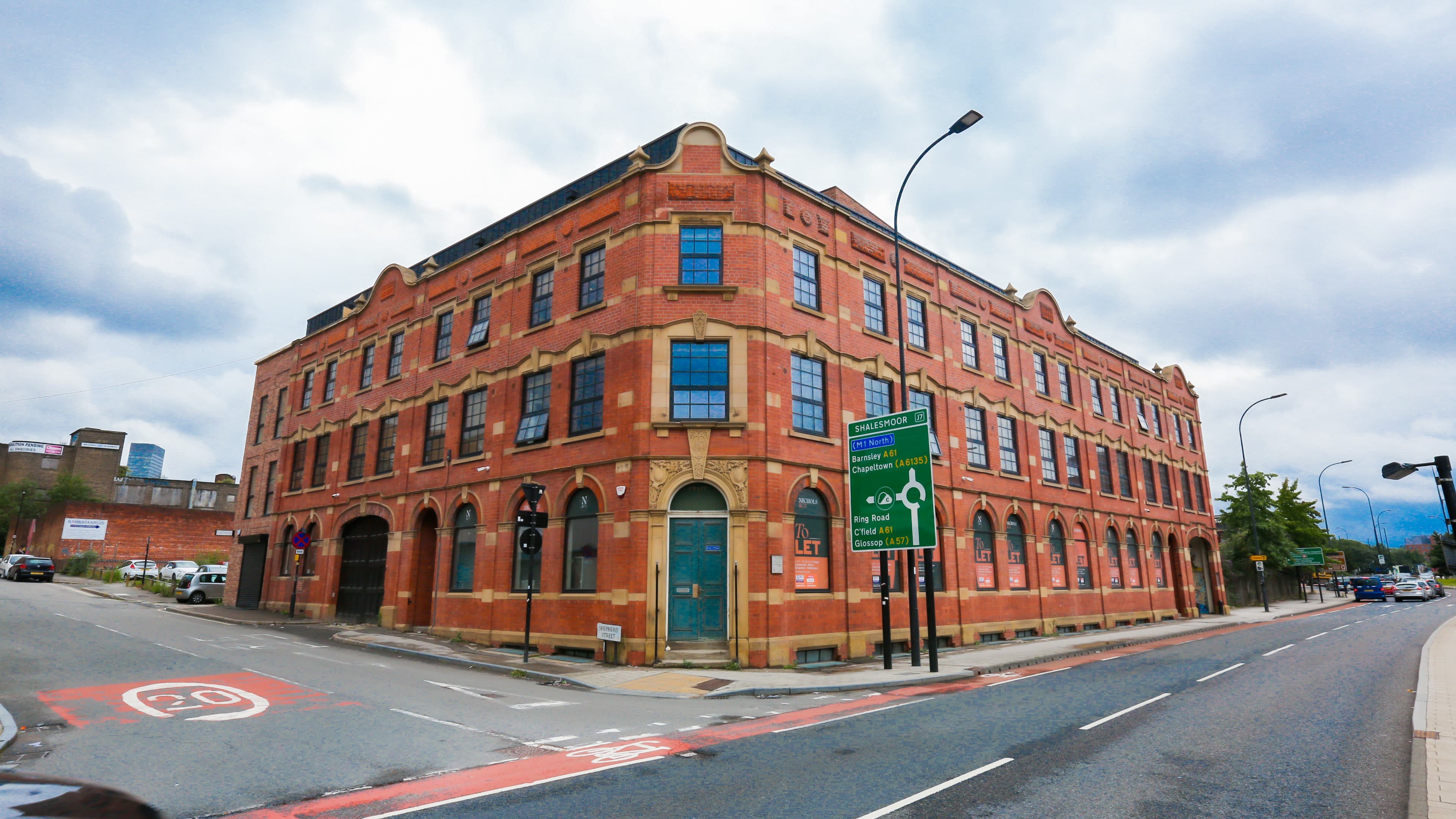 Exterior view of The Nichols Building, red brick structure on street corner under bright daylight – The Nichols Bldg, Sheffield Exterior view of The Nichols Building, red brick structure on street corner under bright daylight – The Nichols Bldg, Sheffield