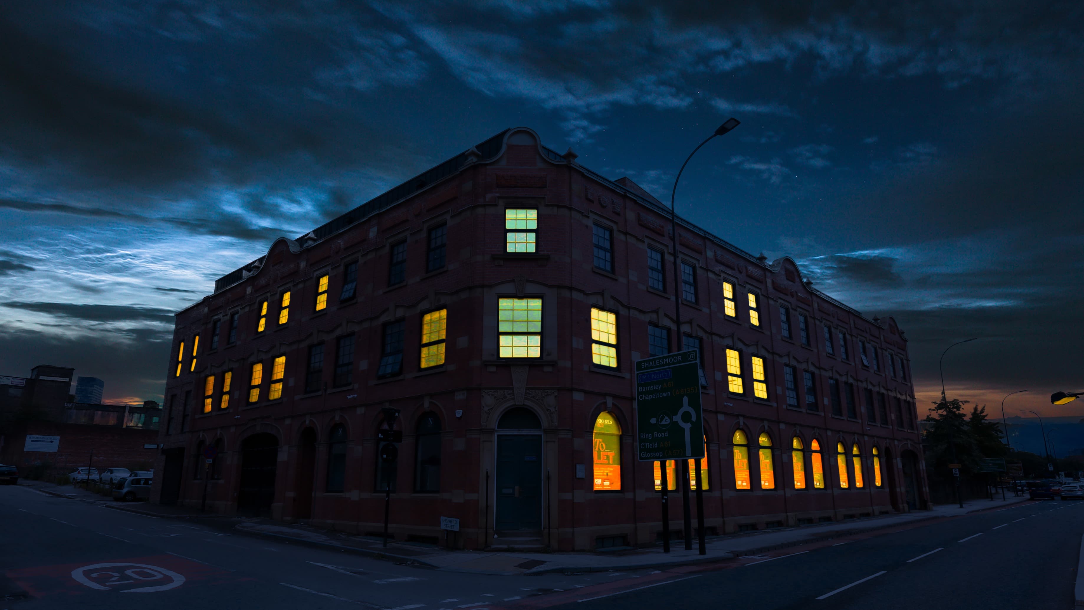 Evening view of The Nichols Building with illuminated windows and dramatic sky – The Nichols Bldg, Sheffield Evening view of The Nichols Building with illuminated windows and dramatic sky – The Nichols Bldg, Sheffield