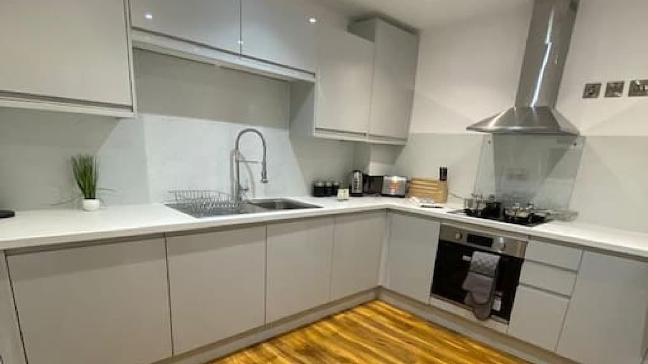 Modern kitchen with light grey cabinets, oven, washing machine, and tiled splashback – De Parys Flat 2, Bedford Modern kitchen with light grey cabinets, oven, washing machine, and tiled splashback – De Parys Flat 2, Bedford