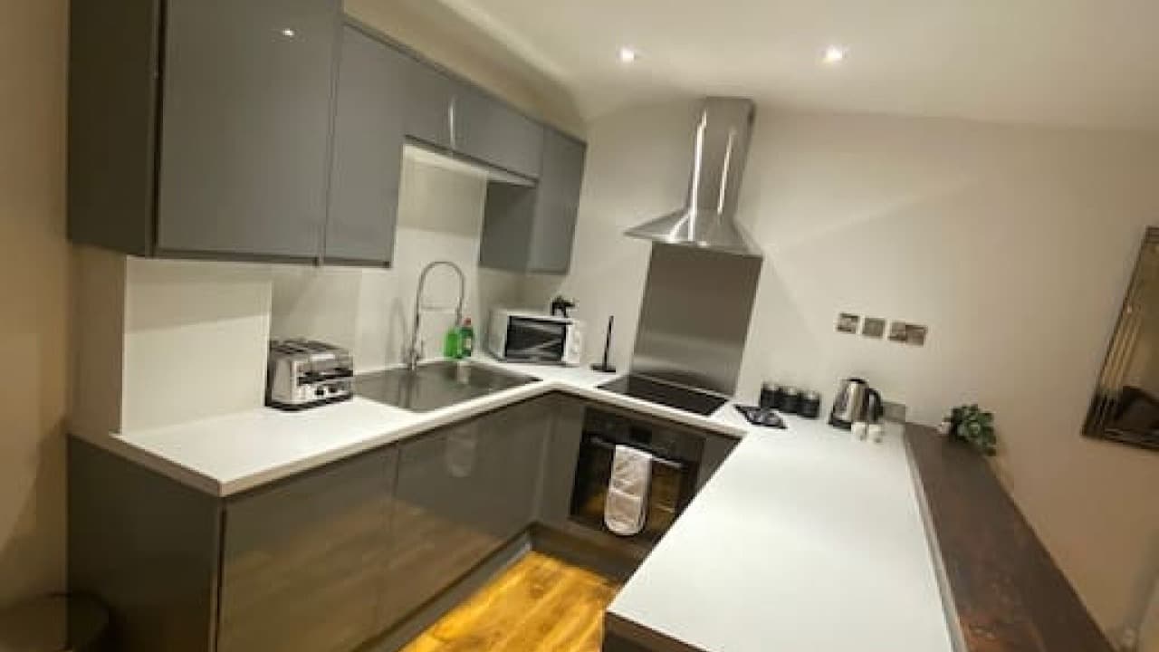 Modern kitchen with grey cabinets, oven, induction hob, and wood-effect countertop – De Parys Flat 5, Bedford Modern kitchen with grey cabinets, oven, induction hob, and wood-effect countertop – De Parys Flat 5, Bedford