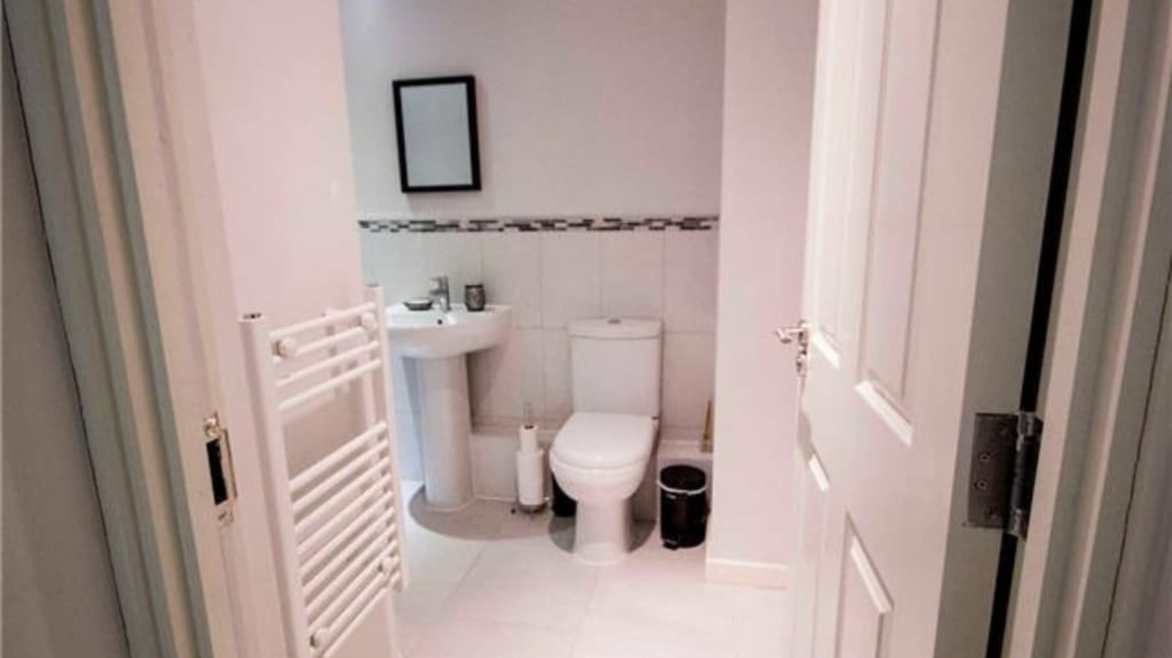 Modern bathroom in serviced flat with white tiling, pedestal sink, toilet, and heated towel rail – Grattan 1 - Bradford, Bradford Modern bathroom in serviced flat with white tiling, pedestal sink, toilet, and heated towel rail – Grattan 1 - Bradford, Bradford