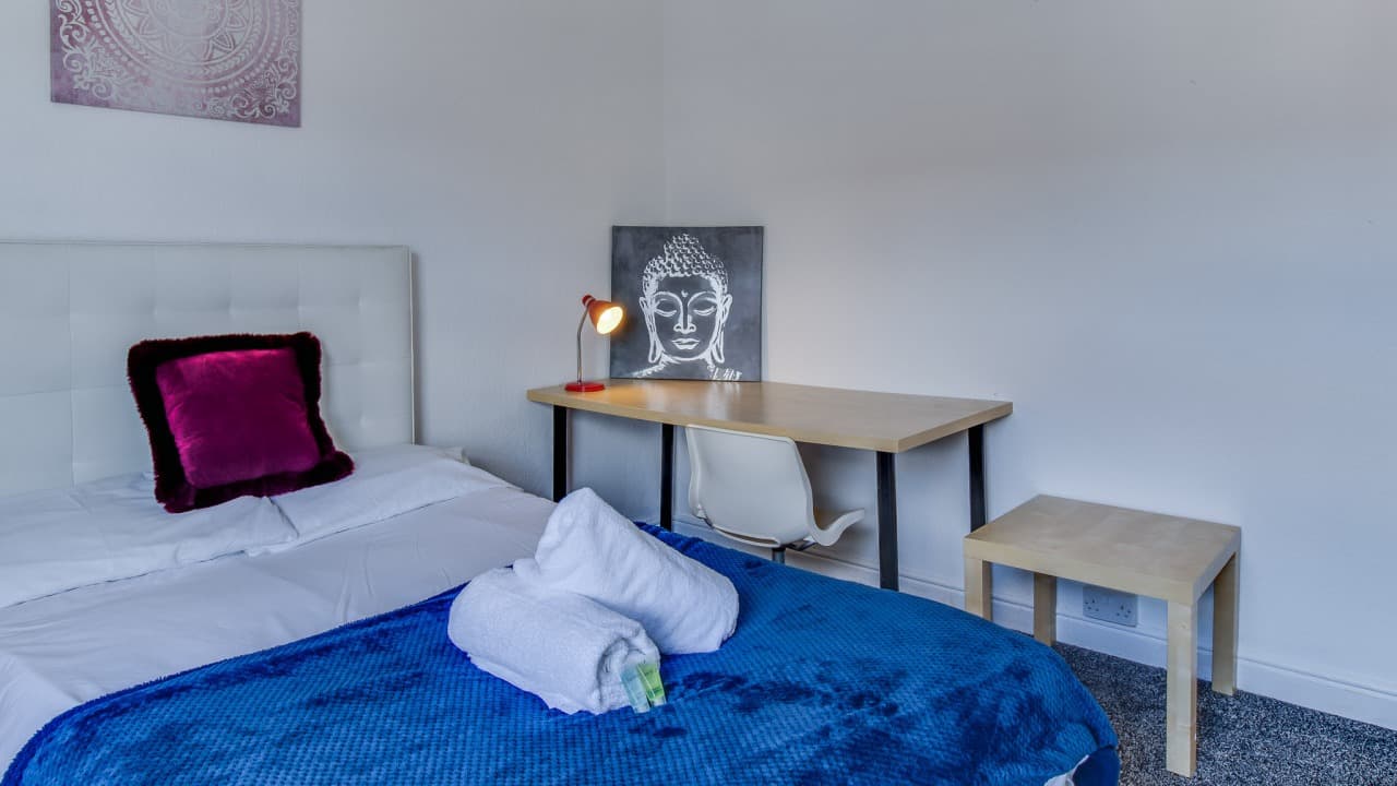 Bright single bedroom with white linens, maroon accent cushion, nightstand, and framed artwork – Terry Road, Coventry Bright single bedroom with white linens, maroon accent cushion, nightstand, and framed artwork – Terry Road, Coventry