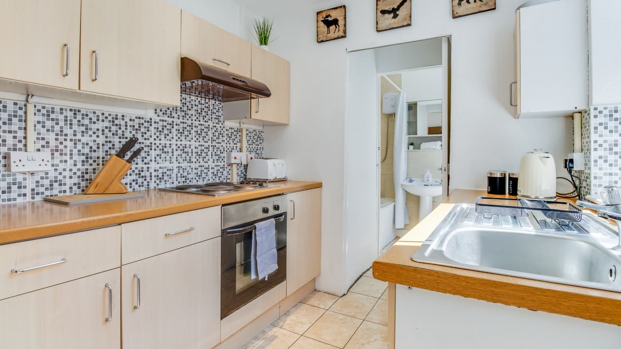 Modern kitchen with white cabinets, oven, tiled backsplash, and open layout to hallway – Terry Road, Coventry Modern kitchen with white cabinets, oven, tiled backsplash, and open layout to hallway – Terry Road, Coventry