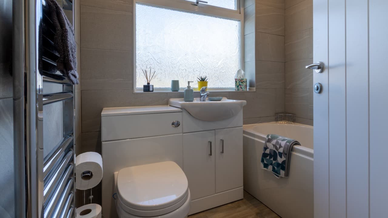 Modern bathroom with large window, white basin, and towel rack in Altham Place bungalow, Morecambe Modern bathroom with large window, white basin, and towel rack in Altham Place bungalow, Morecambe