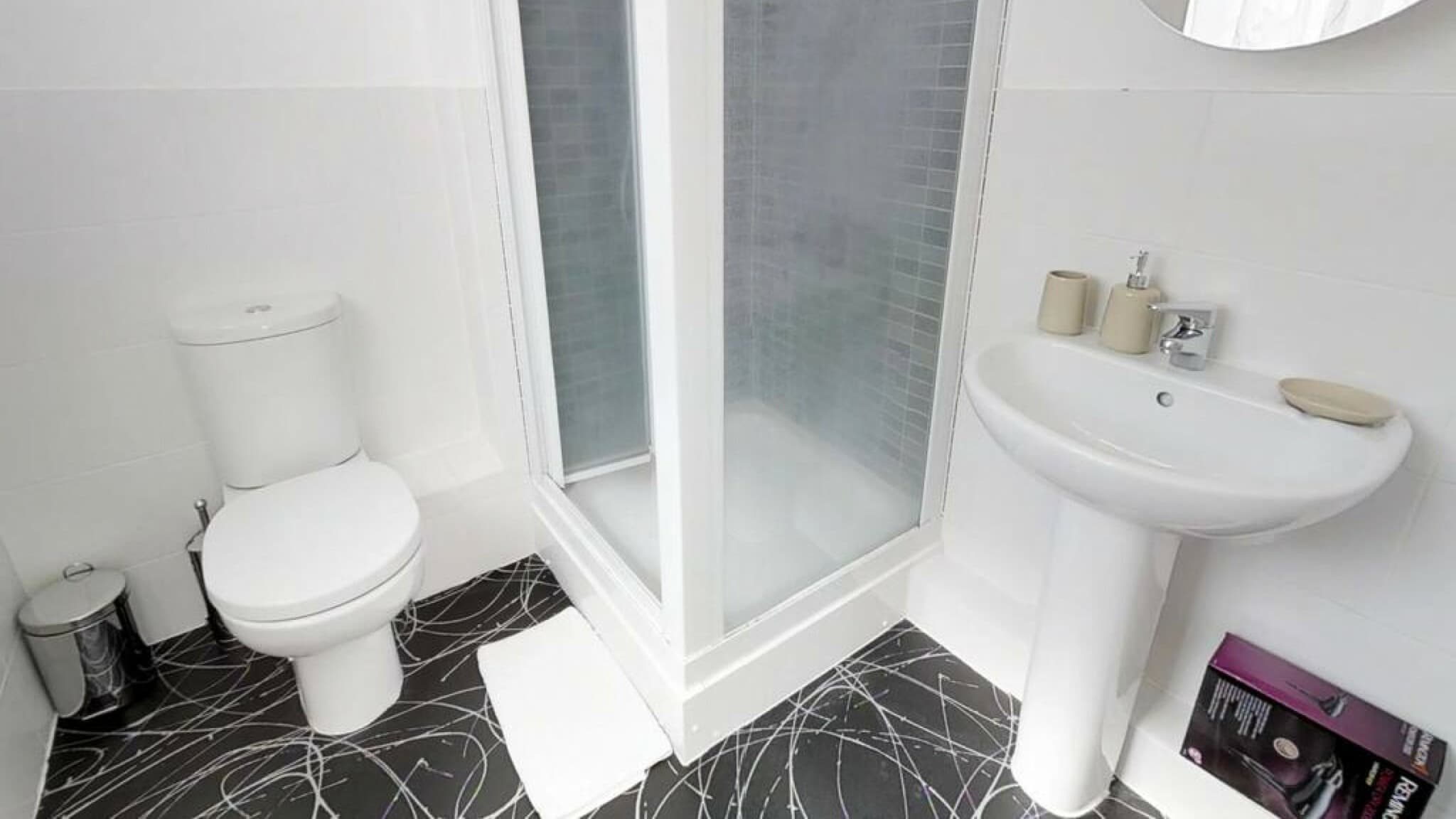 En-suite bathroom with corner shower, white pedestal sink, and toilet at Cole Green Lane-Herts, Welwyn Garden City serviced accommodation En-suite bathroom with corner shower, white pedestal sink, and toilet at Cole Green Lane-Herts, Welwyn Garden City serviced accommodation