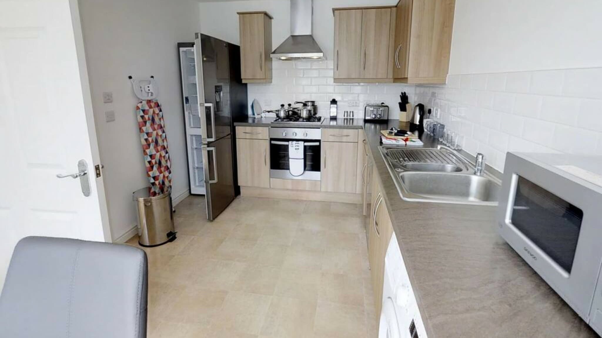 Modern kitchen with dining area, integrated oven, and white cabinets at Cole Green Lane-Herts serviced apartment, Welwyn Garden City Modern kitchen with dining area, integrated oven, and white cabinets at Cole Green Lane-Herts serviced apartment, Welwyn Garden City